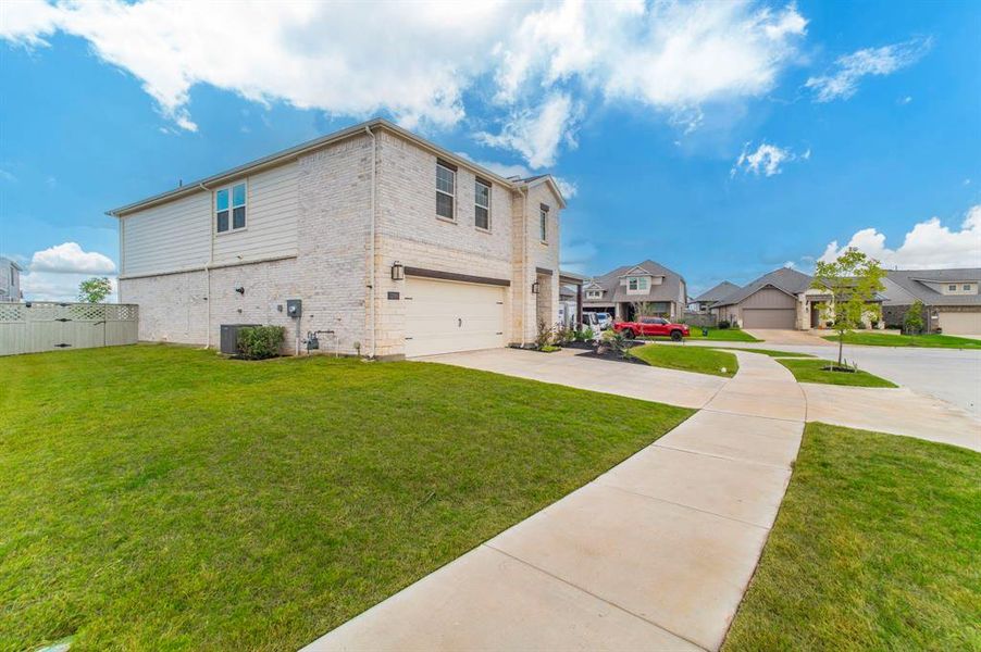 View of property exterior with brick siding, a residential view, driveway, and an attached garage View of property exterior with brick siding, a residential view, driveway, and an attached garage