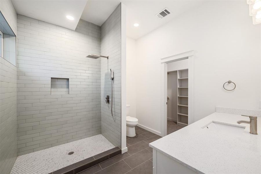 Bathroom featuring visible vents, a shower stall, toilet, tile patterned floors, and vanity