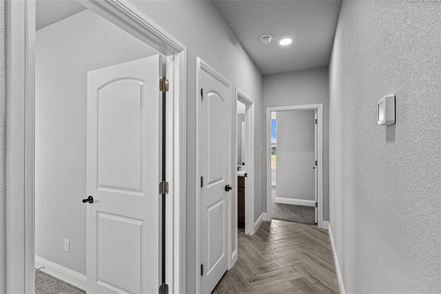 Hallway with a textured wall and recessed lighting Hallway with a textured wall and recessed lighting