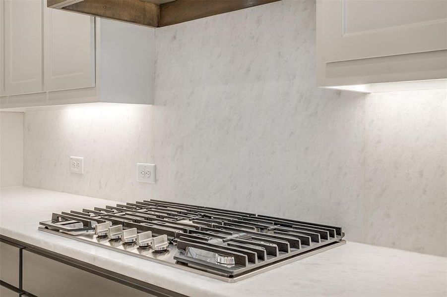 Interior details featuring white cabinets and stainless steel gas cooktop