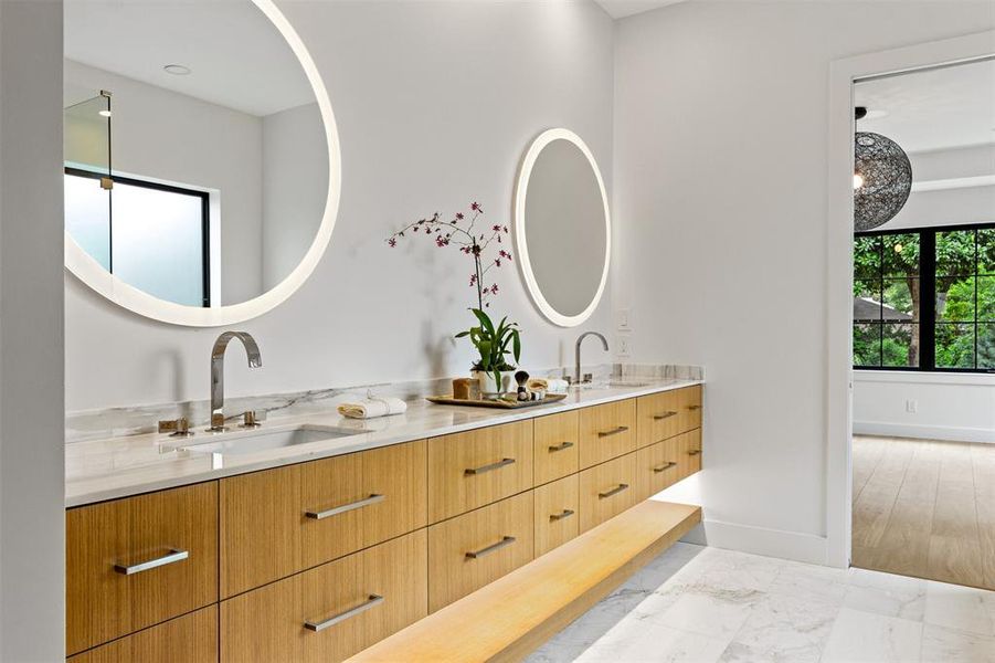 Bathroom with double vanity and marble finish floors