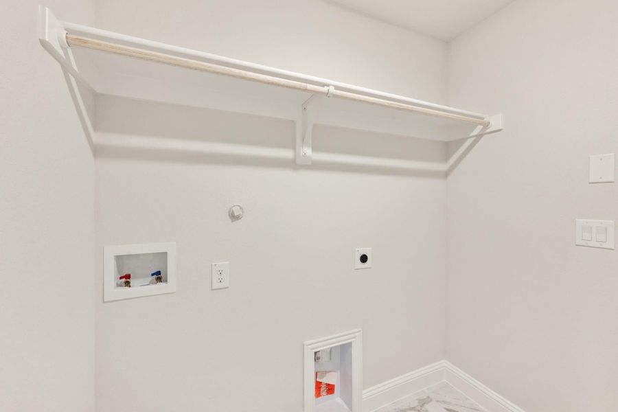 Laundry room with wall-mounted drying rack, washer hookups, and dryer vent connection on white walls