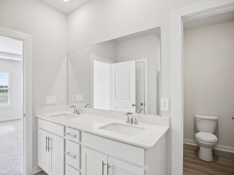 The primary bathroom offers dual vanity sinks and a walk-in shower.