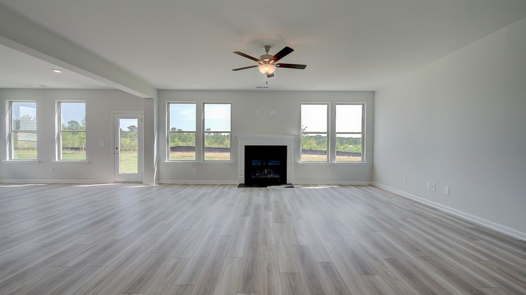 Expansive family room with shiplap wall accent, gas fireplace, and LVP flooring in Clarity at Brighton in Locust Grove, GA.