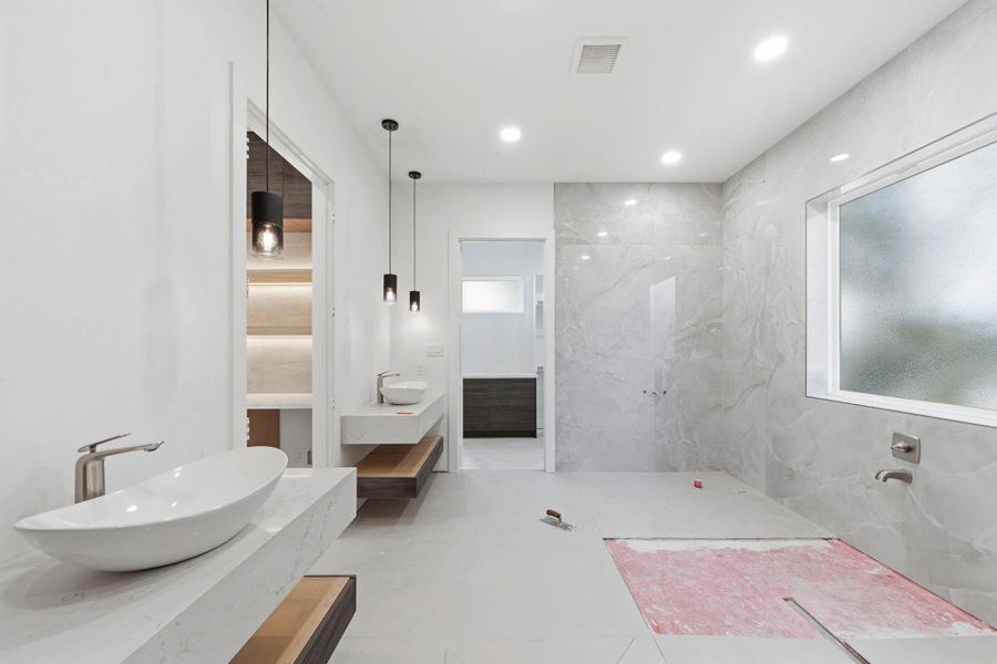 The spa-like primary bathroom features a sleek, modern design with a wet room, double vanities, and two large walk-in closets. The spa-like primary bathroom features a sleek, modern design with a wet room, double vanities, and two large walk-in closets.
