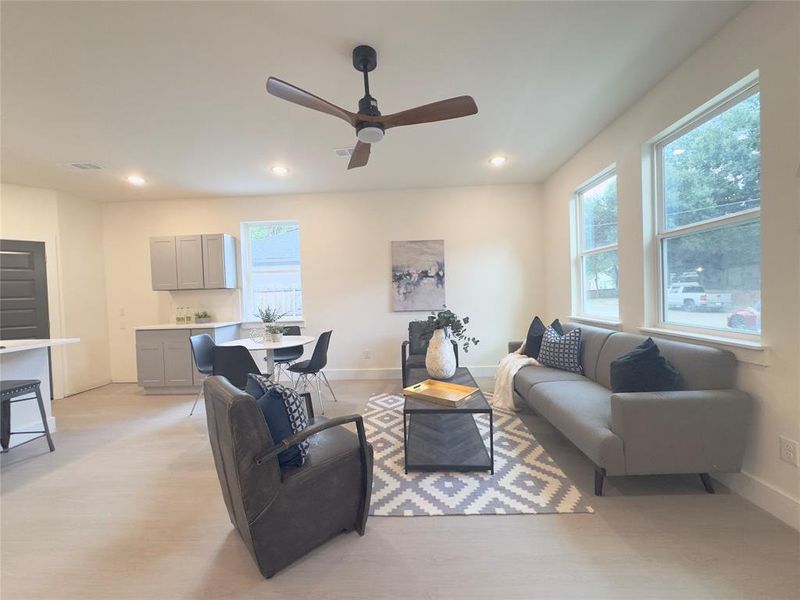 Living room with light hardwood / wood-style flooring and ceiling fan