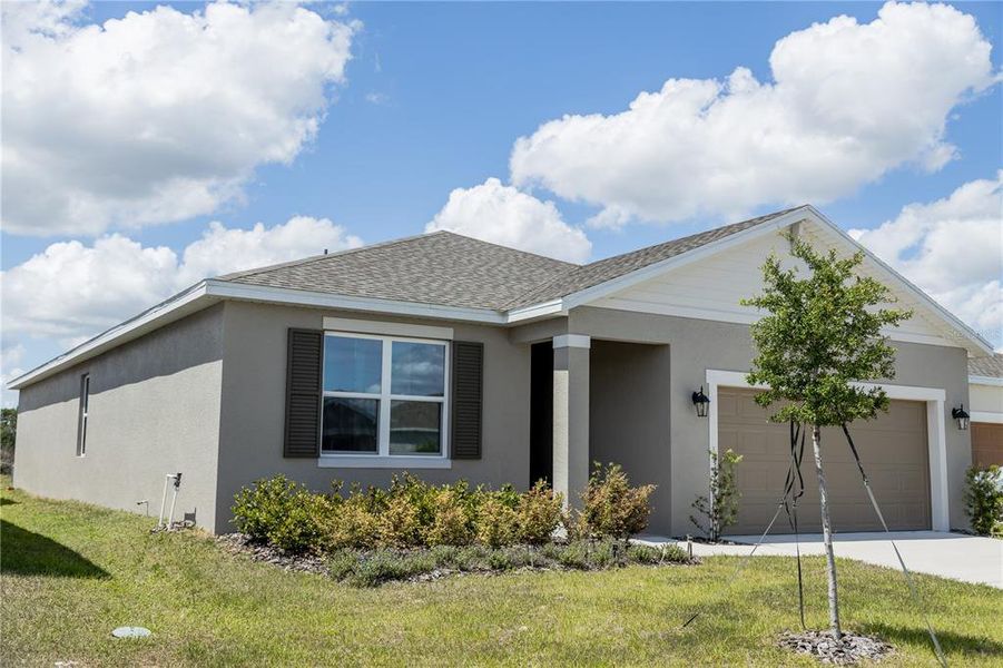 Front exterior of a new home in Village at Windsor Reserve, Eagle Lake, FL, highlighting curb appeal (Image 1). Front exterior of a new home in Village at Windsor Reserve, Eagle Lake, FL, highlighting curb appeal (Image 1).