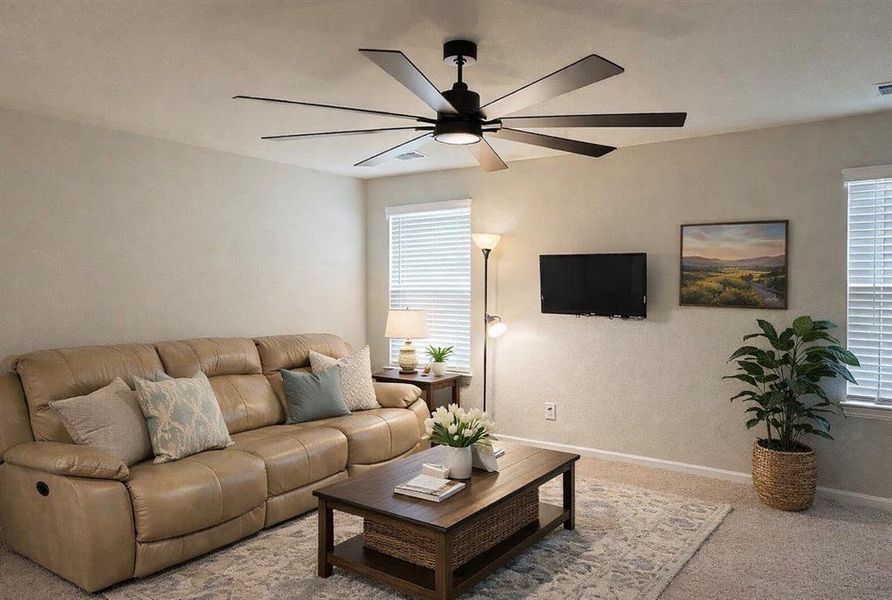 Carpeted living room featuring baseboards and ceiling fan