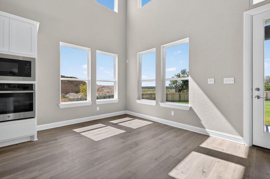 Unfurnished dining area featuring light wood finished floors and a high ceiling