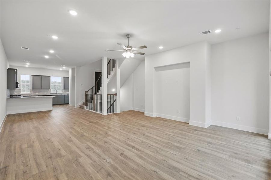 Unfurnished living room featuring a ceiling fan, light wood finished floors, and recessed lighting