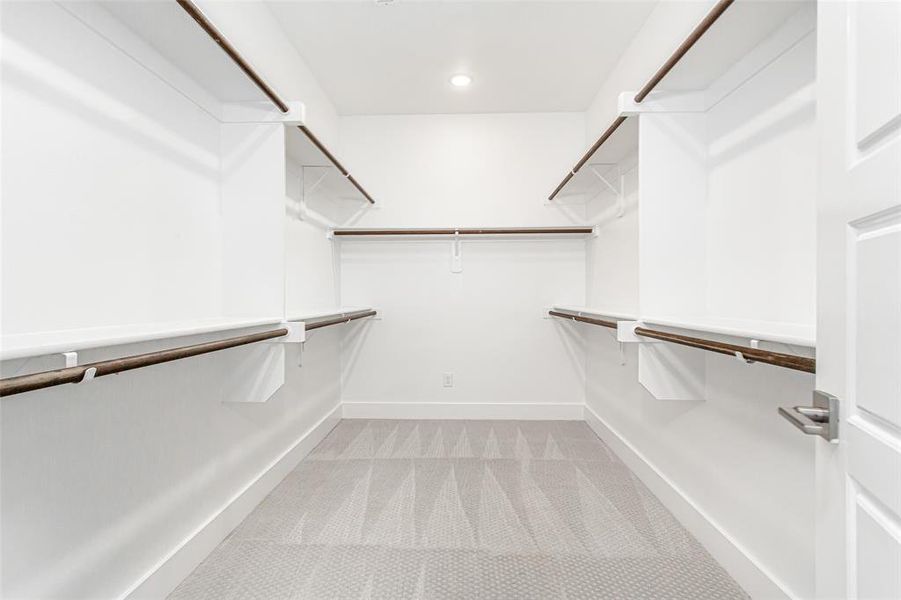 Walk in closet with light colored carpet