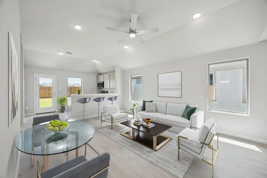 Living room featuring light wood finished floors, vaulted ceiling, ceiling fan, and recessed lighting