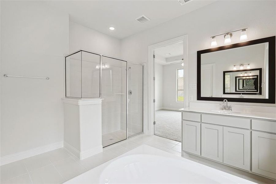 Bathroom with vanity, shower with separate bathtub, and tile patterned flooring