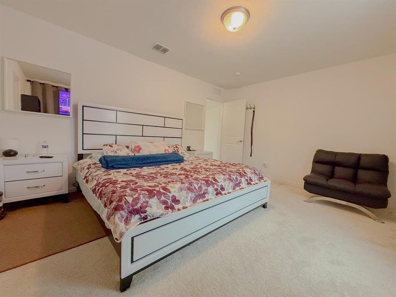 Bedroom with carpet floors and visible vents