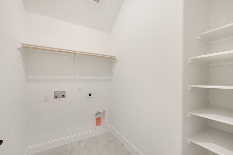 Laundry room with washer and dryer hookups, hanging rod, and built-in white shelving unit