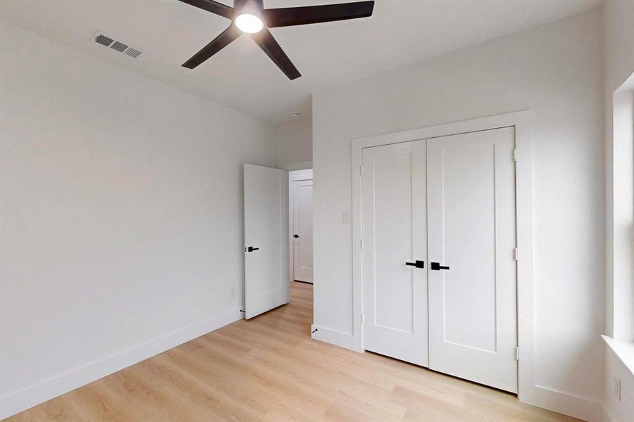 Unfurnished bedroom with light wood finished floors, a closet, and a ceiling fan Unfurnished bedroom with light wood finished floors, a closet, and a ceiling fan