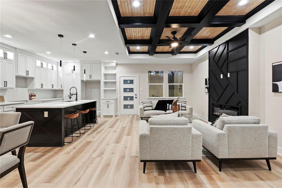 Living area featuring coffered ceiling, recessed lighting, light wood finished floors, wood ceiling, and a ceiling fan Living area featuring coffered ceiling, recessed lighting, light wood finished floors, wood ceiling, and a ceiling fan