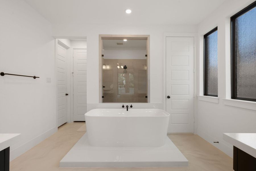 A freestanding soaking tub anchors this well-appointed bath, offering a serene retreat. A freestanding soaking tub anchors this well-appointed bath, offering a serene retreat.