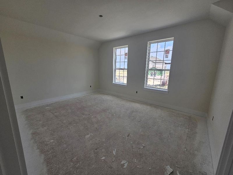 Empty room featuring lofted ceiling and baseboards Empty room featuring lofted ceiling and baseboards