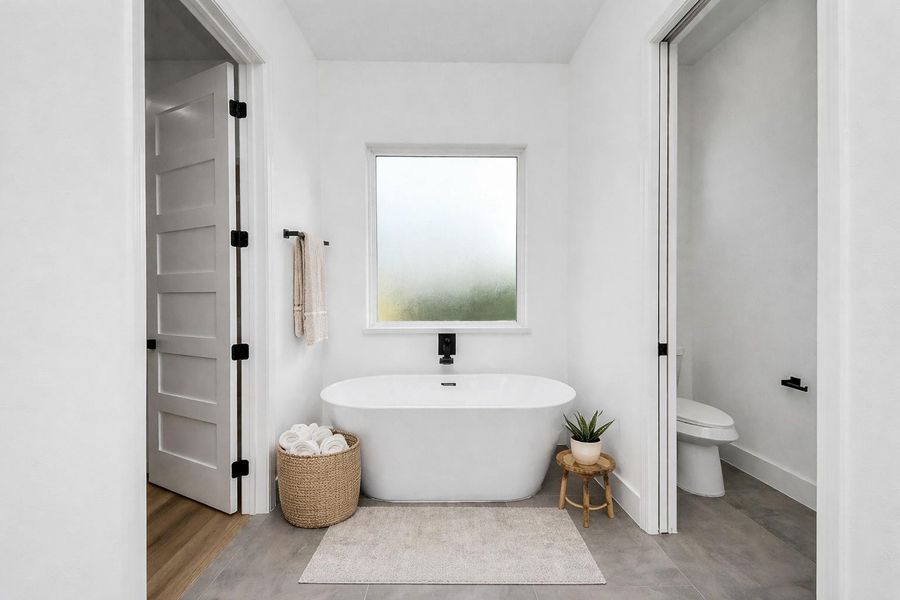 Spa-like primary bathroom retreat featuring a freestanding soaking tub, walk-in shower, and clean modern finishes.
