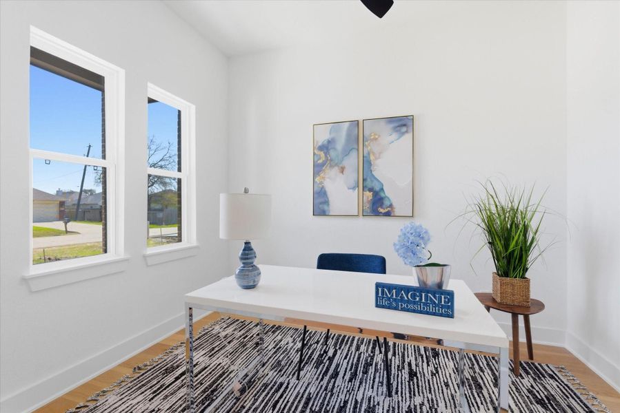 Dedicated home office featuring a ceiling fan and forward-facing windows that provide abundant natural light creating a comfortable work environment.