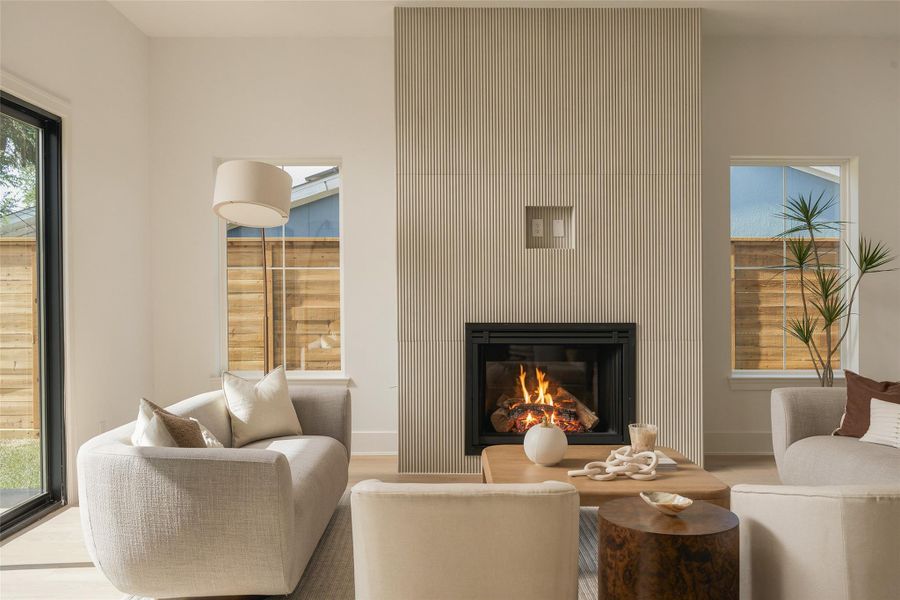 The dining and living spaces flow together beneath 11-foot ceilings, while expansive glass doors draw the eye toward the covered patio and backyard beyond—creating a seamless setting for indoor-outdoor entertaining.
