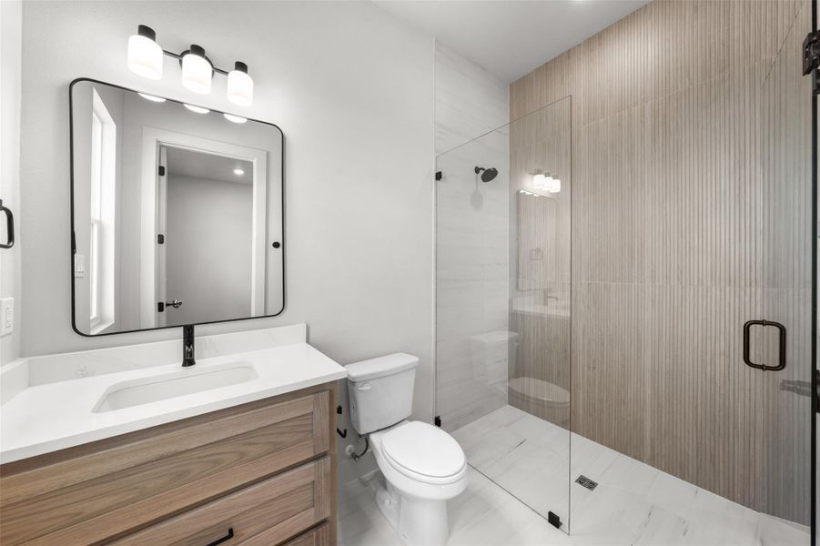 Full bath featuring a shower, toilet, and vanity Full bath featuring a shower, toilet, and vanity