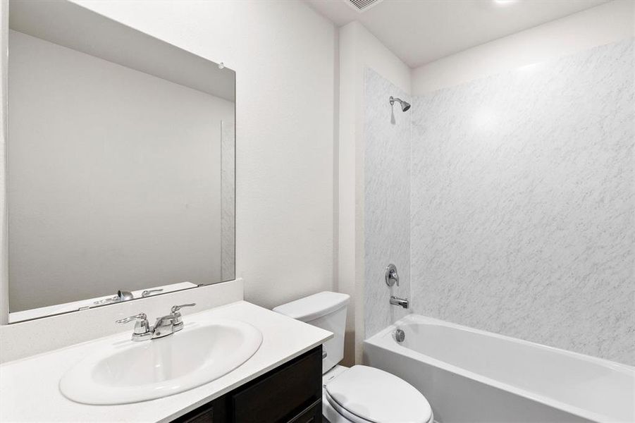 Bathroom featuring a single vanity with an integrated sink, polished chrome faucet, and a large wall-mounted mirror