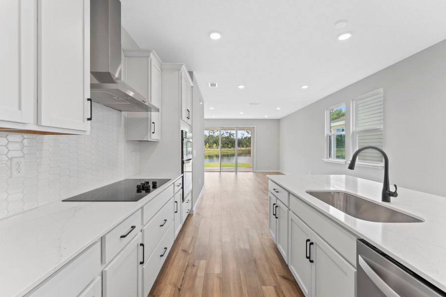 Miramar Floorplan Lot 81 Kitchen with White Cabinets and Black Hardware at Concourse Crossing in Fernandina Beach