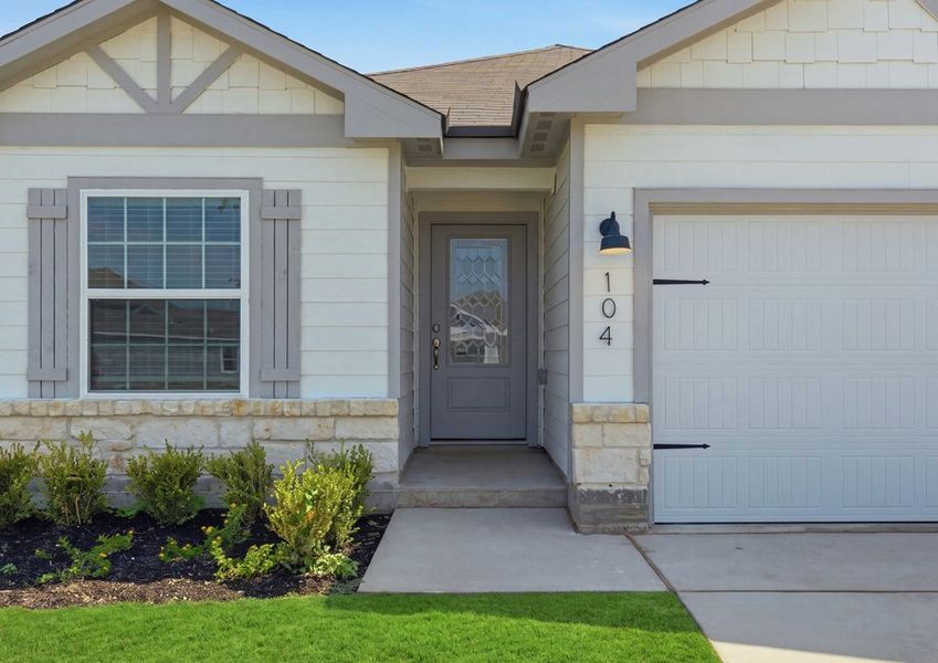 Single-story Frio floor plan front exterior featuring lap siding, a two-car garage, and landscaped front lawn. Single-story Frio floor plan front exterior featuring lap siding, a two-car garage, and landscaped front lawn.
