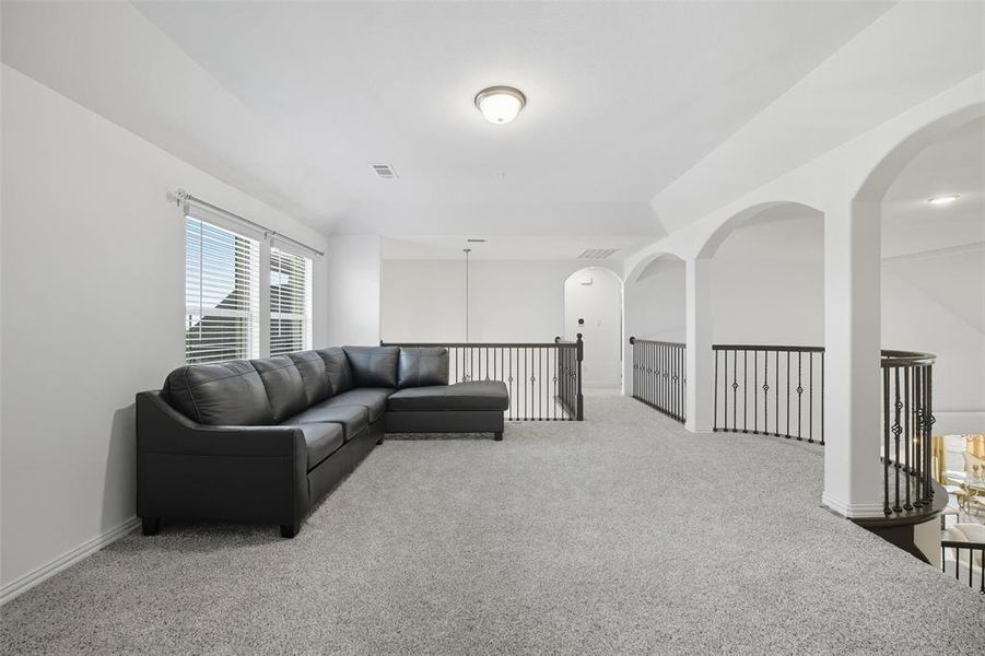2nd floor Living area featuring light colored carpet and arched walkways 2nd floor Living area featuring light colored carpet and arched walkways