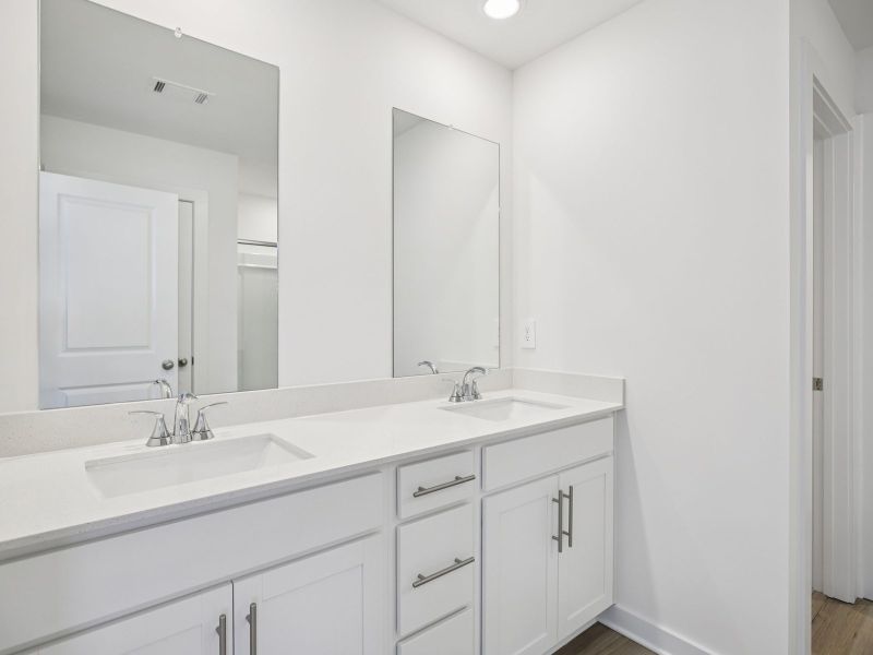 The primary bathroom offers dual vanity sinks and a walk-in shower.