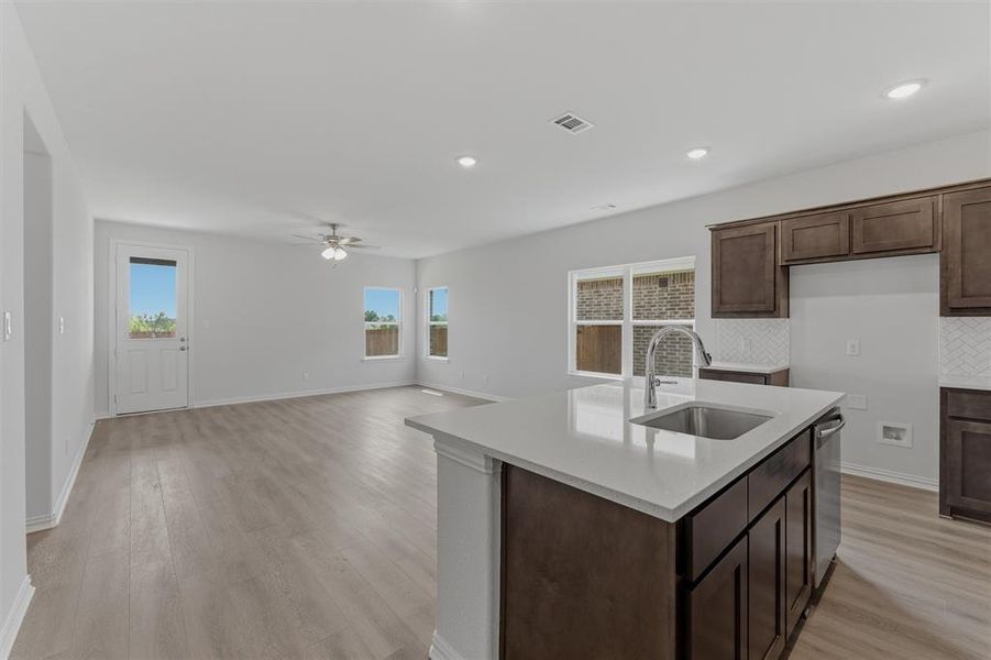 Open-concept living space featuring wood-finish flooring, recessed lighting, and a ceiling fan