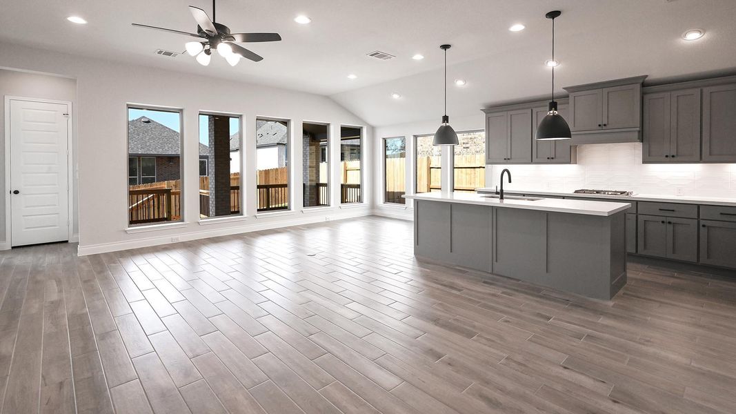 Kitchen featuring stainless steel gas stovetop, light countertops, ceiling fan, a sink, and gray cabinets Kitchen featuring stainless steel gas stovetop, light countertops, ceiling fan, a sink, and gray cabinets