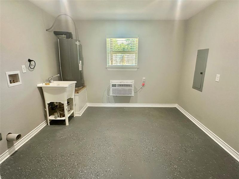 Downstairs Laundry room with water heater, a wall mounted AC, electric panel, and washer hookup Downstairs Laundry room with water heater, a wall mounted AC, electric panel, and washer hookup