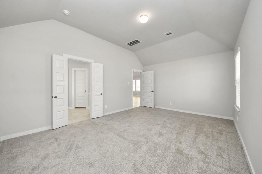 Come and unwind after a long day in this magnificent primary suite! This spacious room features plush carpet, warm paint, high ceilings and large windows with privacy blinds. Sample photo of completed home with similar floor plan. Actual colors and selections may vary.