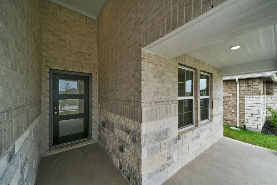 Inviting covered entry featuring a modern door and classic brickwork.
