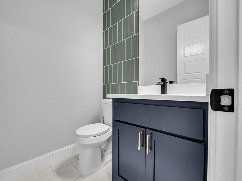 Half bath with vanity and light tile patterned floors located on level 1 Half bath with vanity and light tile patterned floors located on level 1