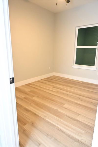Spare room with light wood-style floors and baseboards