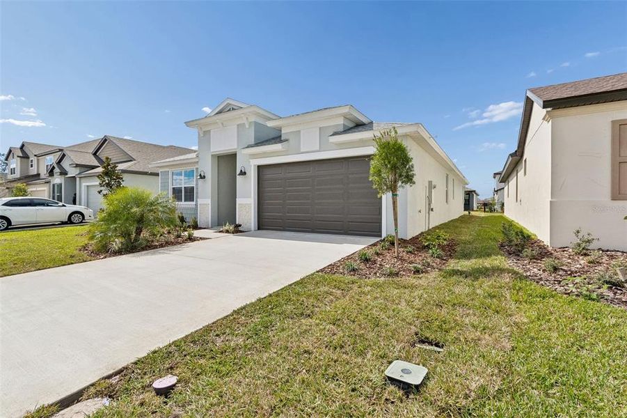 Front exterior of a new home in Isles at Bayview, Parrish, FL, highlighting curb appeal (Image 2). Front exterior of a new home in Isles at Bayview, Parrish, FL, highlighting curb appeal (Image 2).