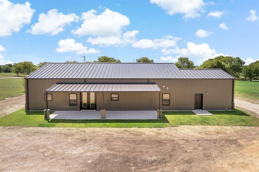 Back of property featuring a patio and a lawn