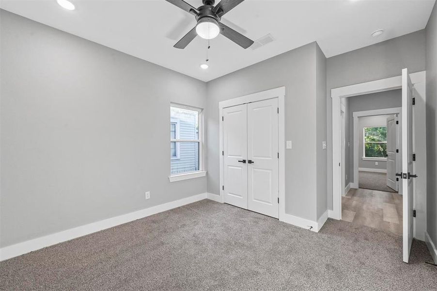 Unfurnished bedroom featuring a closet, carpet, and ceiling fan