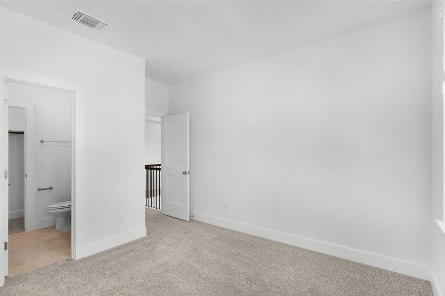 A spacious, neutral room offers flexibility for living or office space, complete with a convenient adjacent bath.