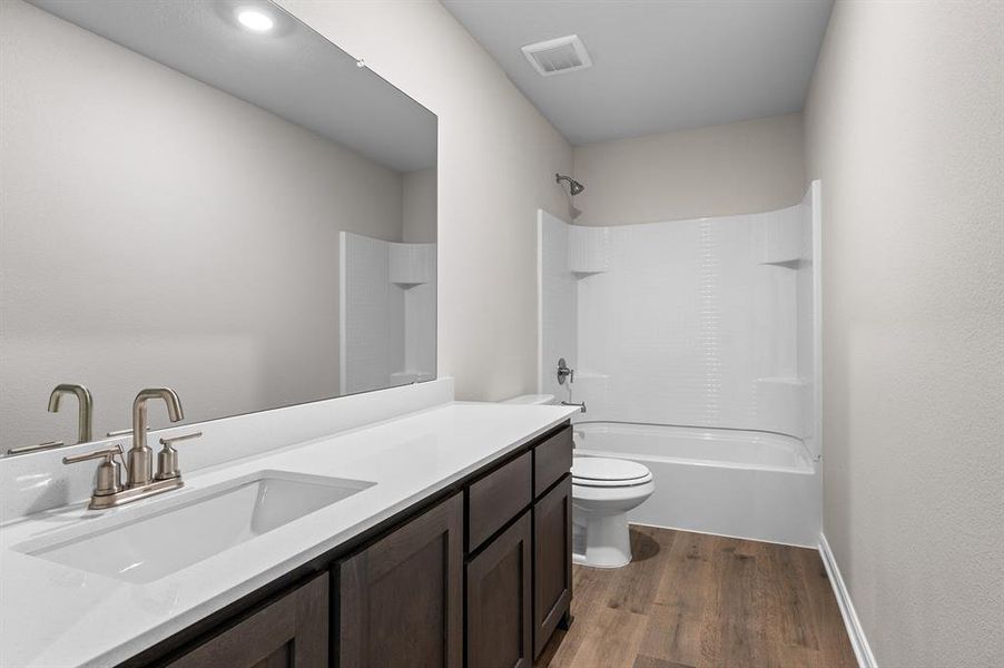 Bathroom featuring shower / bath combination, vanity, and dark wood finished floors Bathroom featuring shower / bath combination, vanity, and dark wood finished floors