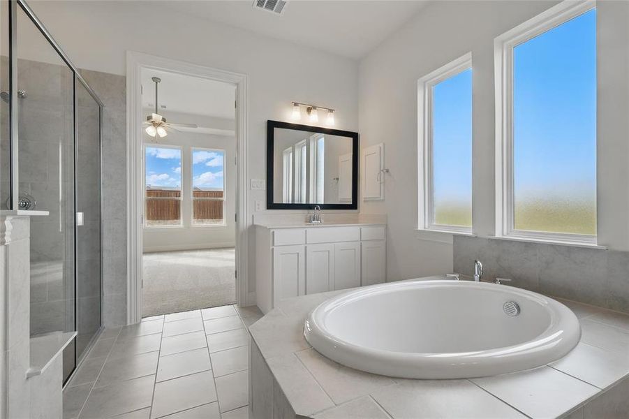 Bathroom with vanity, tile patterned flooring, ceiling fan, a bath, and a stall shower Bathroom with vanity, tile patterned flooring, ceiling fan, a bath, and a stall shower