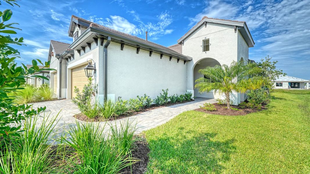 Front exterior of a new home in Vistera of Venice Real Estate and Homes for Sale in Venice, FL - Neal Communities, Nokomis, FL, highlighting curb appeal (Image 19).