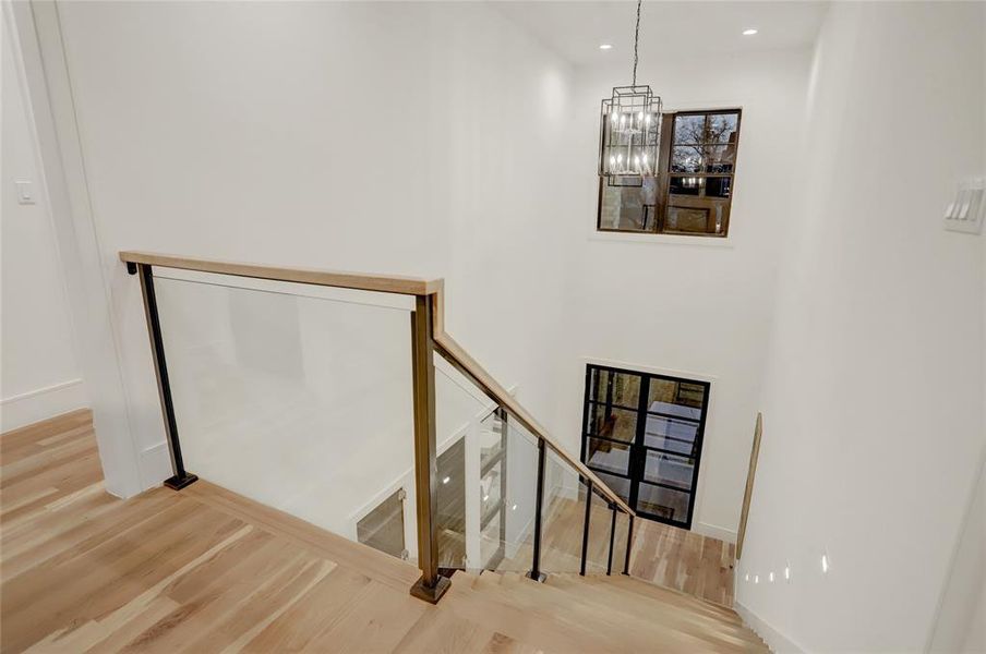 Second story landing showing 2-story stairway and glass balustrade.