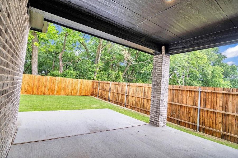 Fenced backyard with a patio area Fenced backyard with a patio area