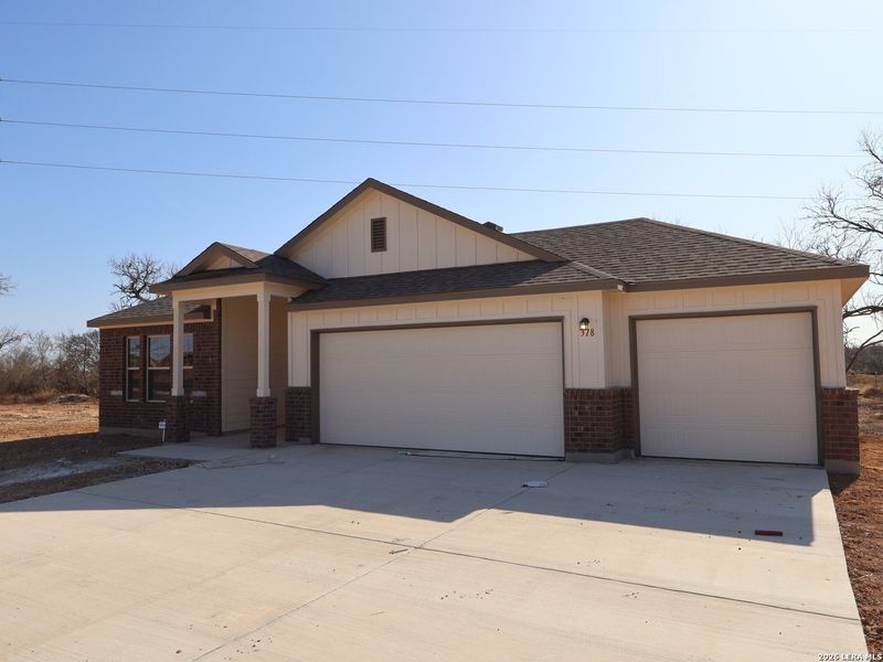 Front exterior of a new home in Jordan's Ranch, San Antonio, TX, highlighting curb appeal (Image 2). Front exterior of a new home in Jordan's Ranch, San Antonio, TX, highlighting curb appeal (Image 2).