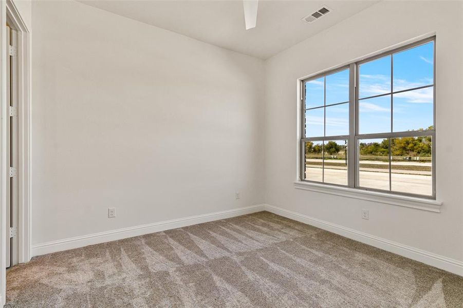 Carpeted empty room featuring ceiling fan